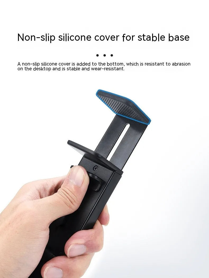 Black foldable ABS phone holder with 360-degree rotation on a desk next to a smartphone