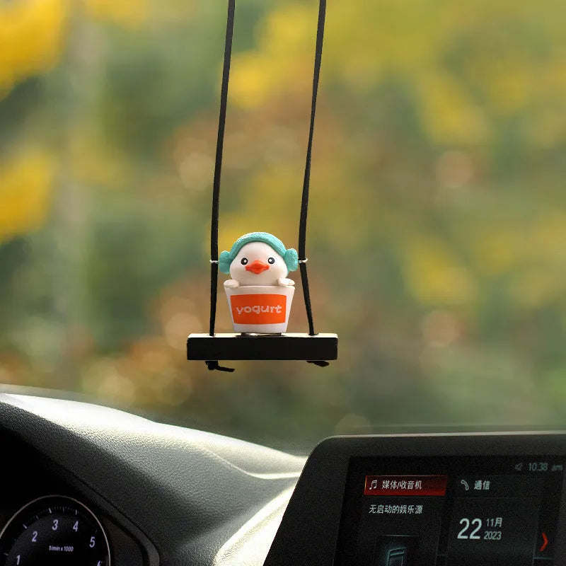 Colourful plastic cartoon duck car hanging ornament on a rear-view mirror.
