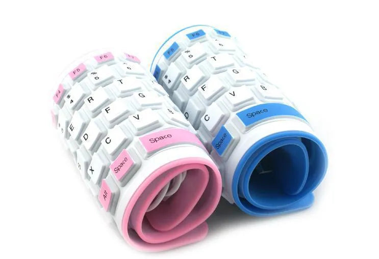 Folding silicone keyboard in pink with USB cable, placed on a desk