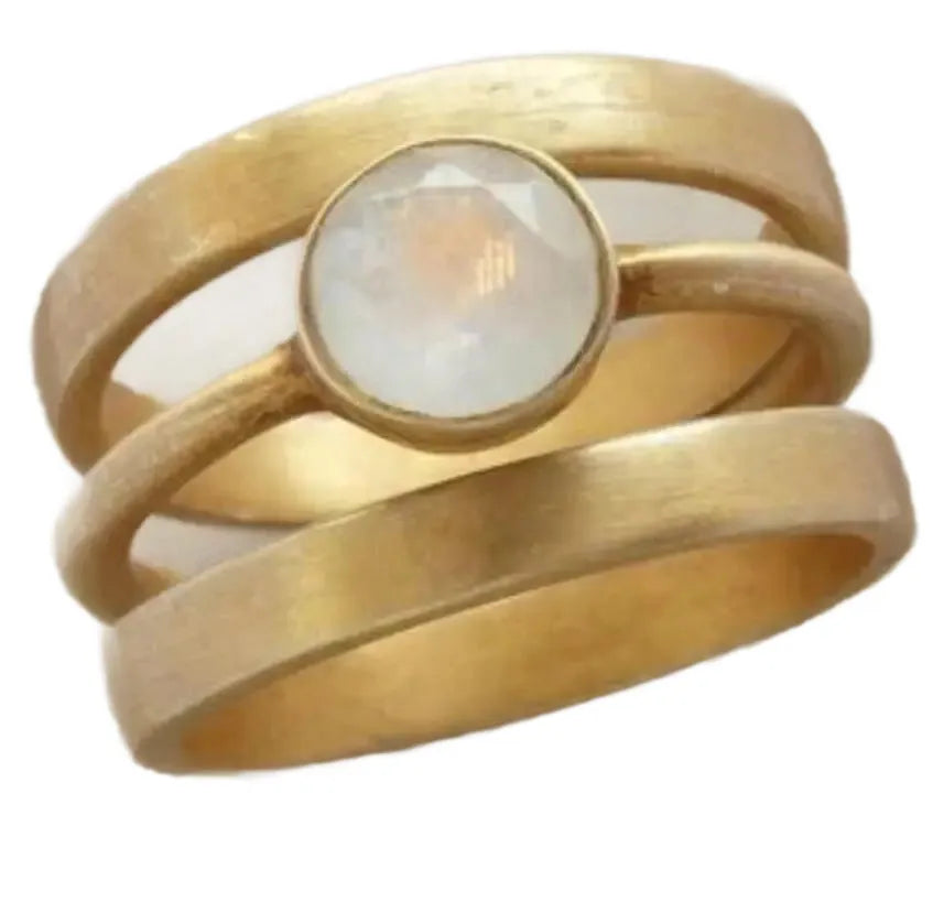 Gold-plated geometric titanium steel ring with a micro-inlaid white chalcedony stone on a grey background.