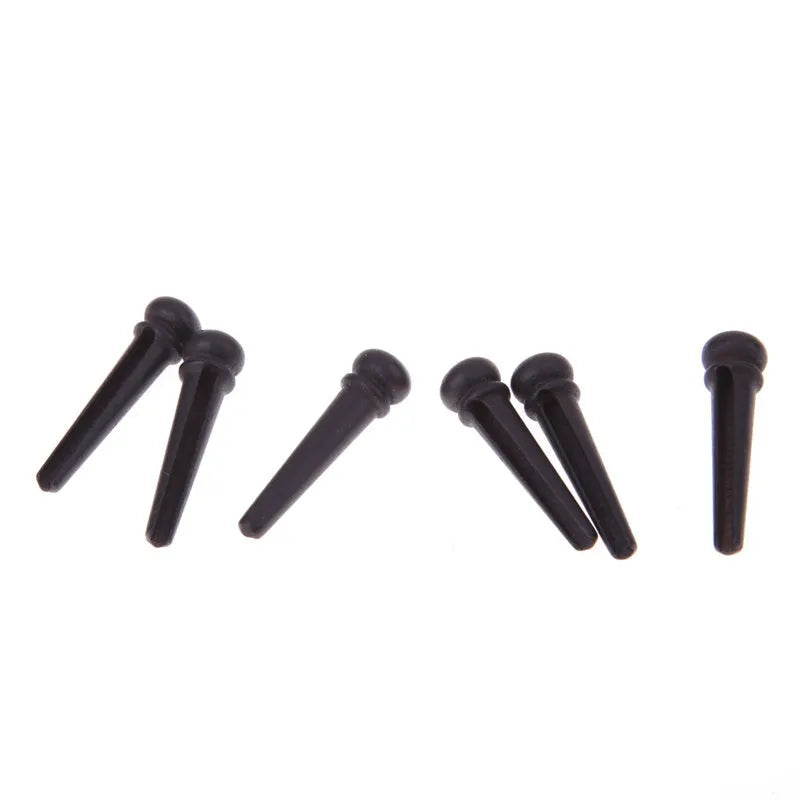 Six ebony guitar bridge pins with matt black finish and 5.3mm bayonet diameter