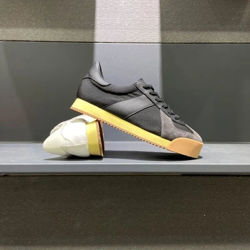 Men's grey suede and mesh sports shoe with a raised heel and herringbone pattern on the toe.