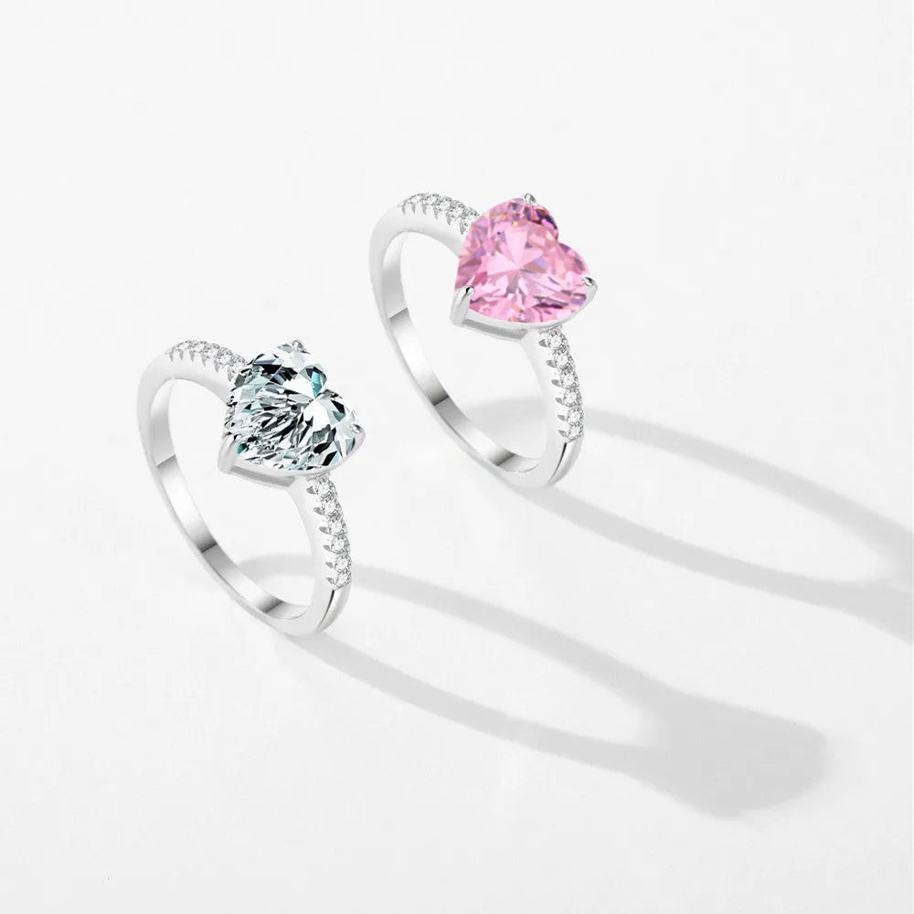 Women's sterling silver love ring with heart zircon mosaic in white color, side view on white background