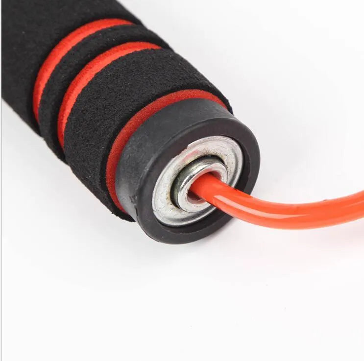 Adjustable Jump Fit Rope with black weighted handles and red speed rope on a dark workout mat