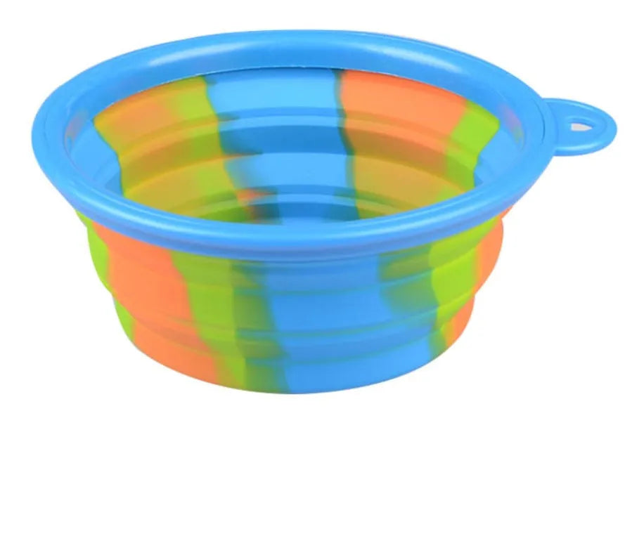 Collapsible silicone dog bowl in camouflage pattern folded flat on green surface