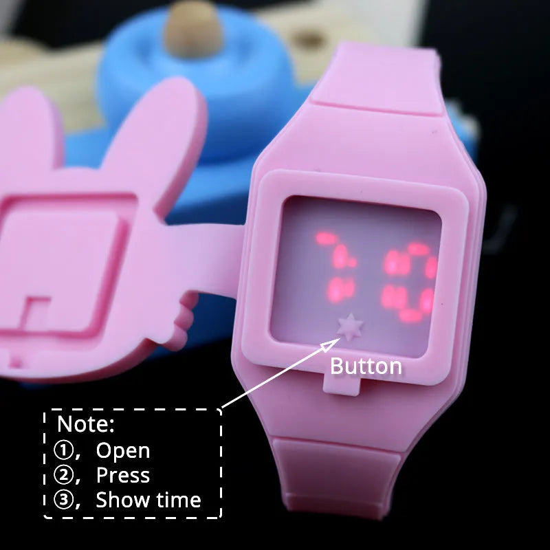 Children's electronic watch with 55mm plastic cartoon dial, silicone strap, and stainless steel pin buckle on a child's wrist