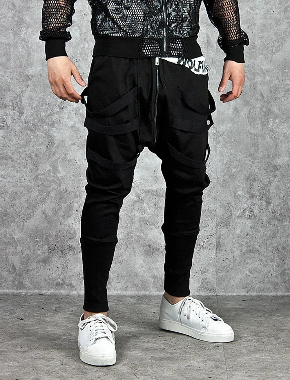 Men's black low crotch cross trousers with tapered cone leg and small hem on a plain background
