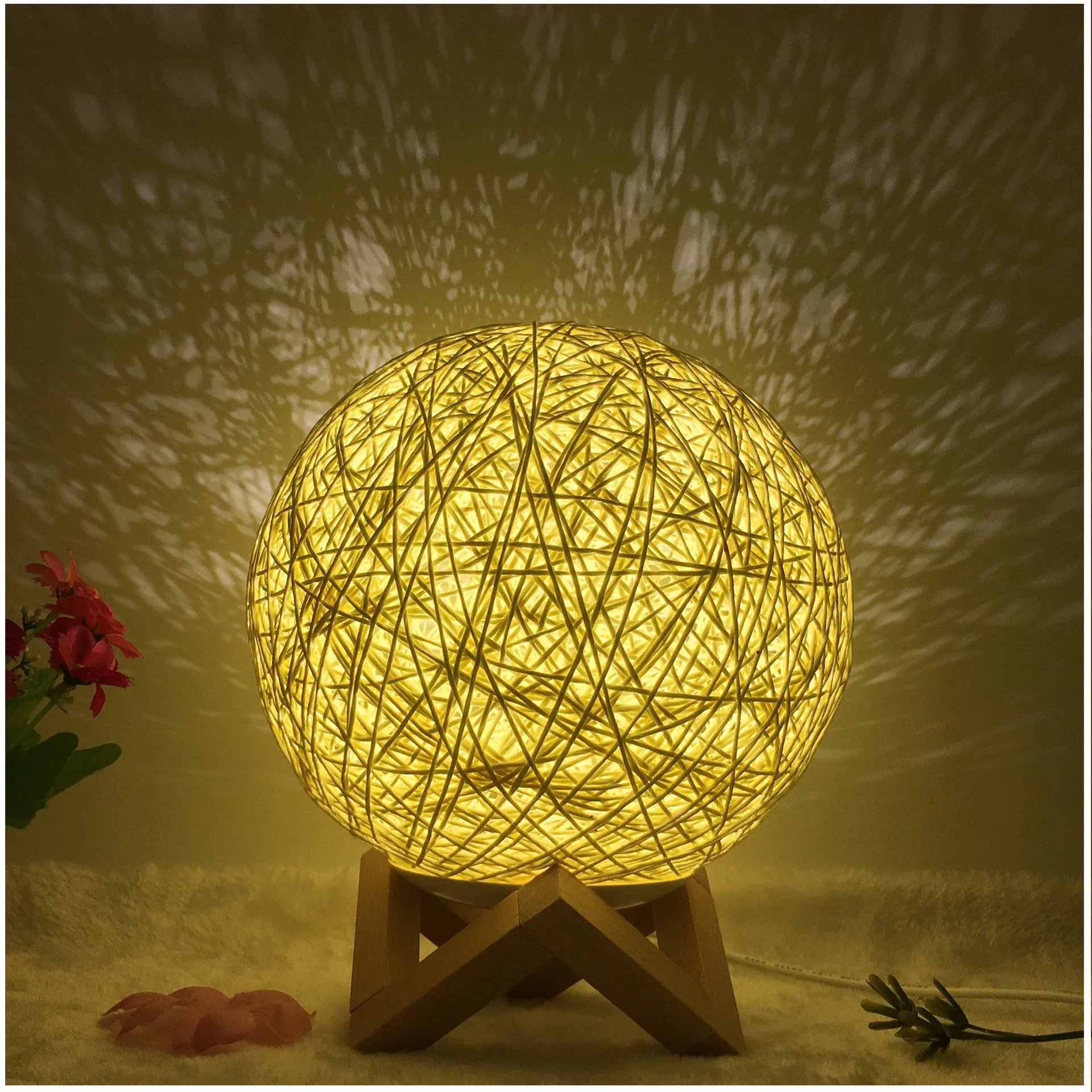 Rattan ball table lamp with woven shade and warm LED lighting on wooden surface