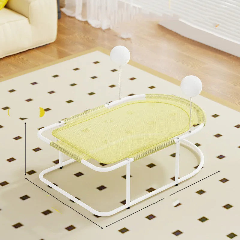 Grey fabric cat kennel with open sides and a round, removable floor pad on a carpet.
