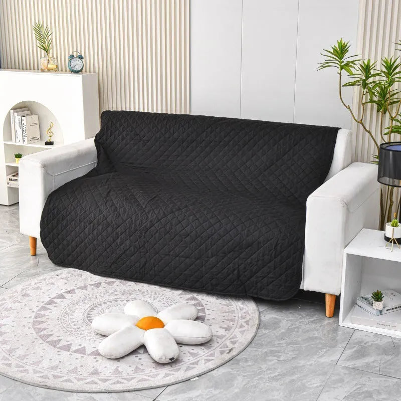 Reversible waterproof dog blanket laid on a sofa, showing two colour options.