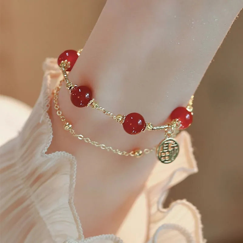 Red agate and alloy double-layer women's bracelet with Hongma blessing card charm on an adjustable fastening.