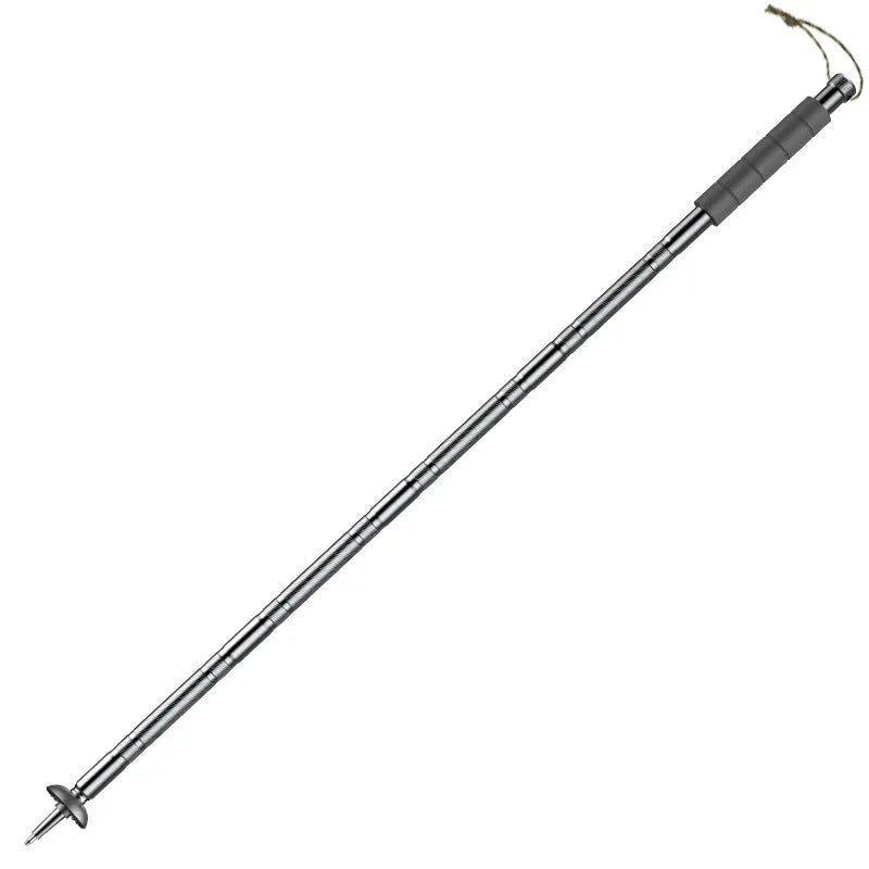 Dark grey aluminium trekking pole with tactical knife and screwdriver accessories on a hiking trail