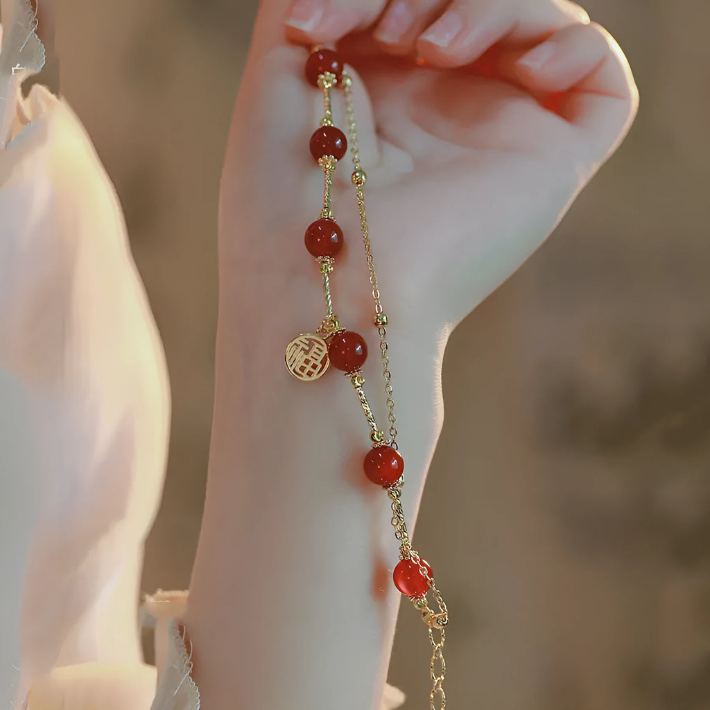 Red agate and alloy double-layer women's bracelet with Hongma blessing card charm on an adjustable fastening.