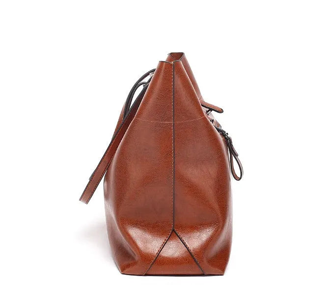 Brown waxed cowhide crossbody handbag showing front flap and adjustable strap against a neutral background.