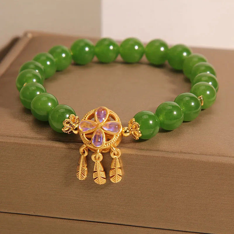 Green jasper crystal four-leaf clover dream catcher pendant on an adjustable women's bracelet.