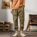 Men's khaki cotton harem pants with ankle bands and a loose, tapered fit.