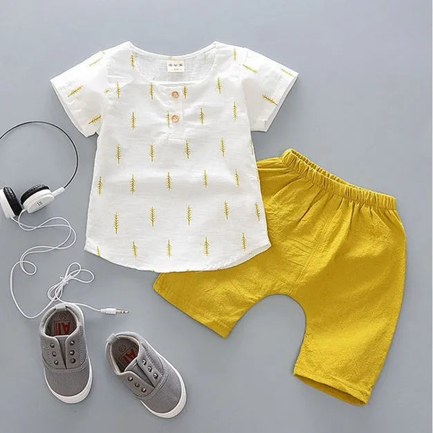 Baby boy wearing a blue cotton short sleeve t-shirt and matching short pants from a summer sports outfit set.