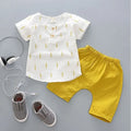 Baby boy wearing a blue cotton short sleeve t-shirt and matching short pants from a summer sports outfit set.