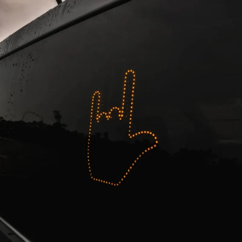Black plastic LED gesture light for cars with remote control showing middle finger symbol