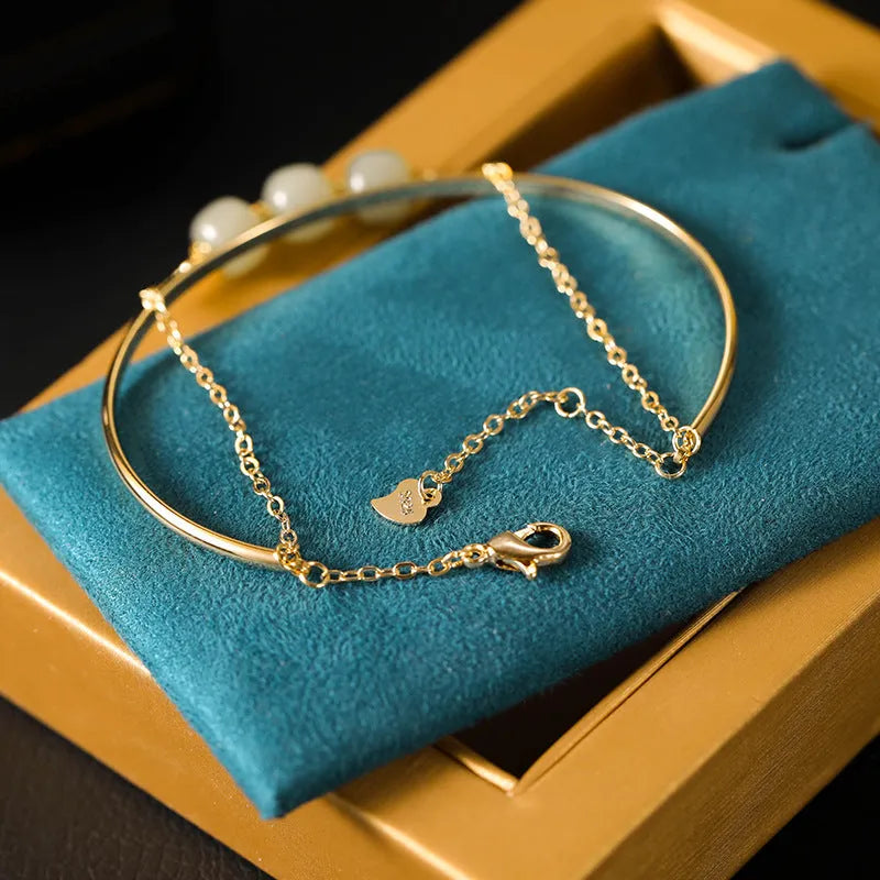 Women's Hetian jade bracelet with gold inlay design in single, double, or three-bead versions.