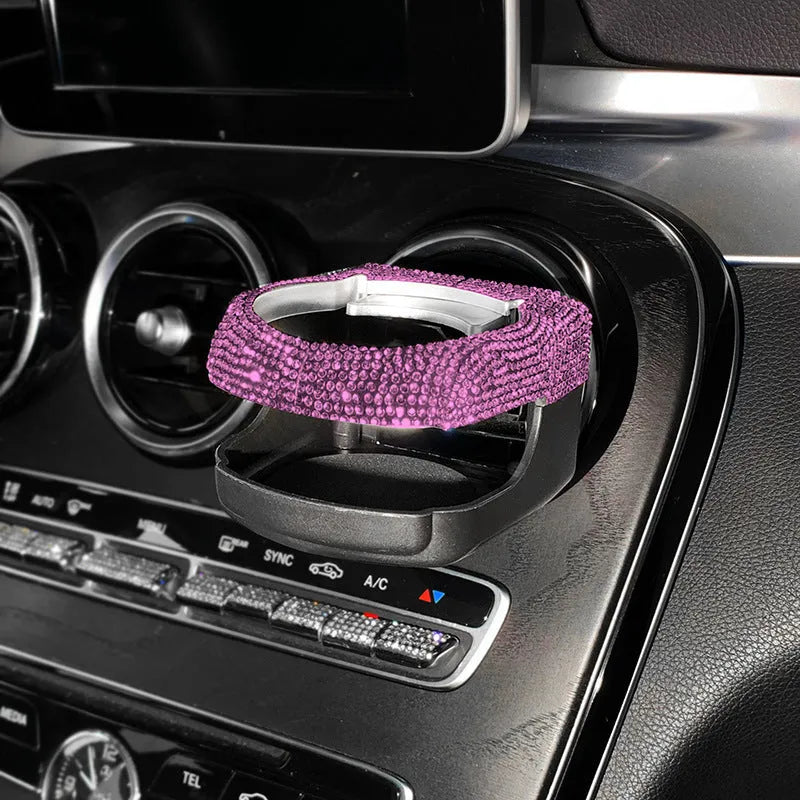 Rhinestone-encrusted white car cup holder bracket mounted on a vehicle air vent.