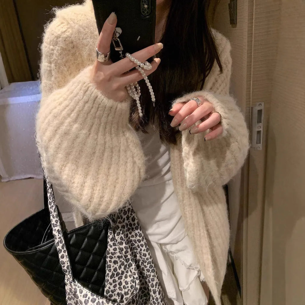 Woman wearing a thick dark grey hooded zip-up cardigan, loose fit.