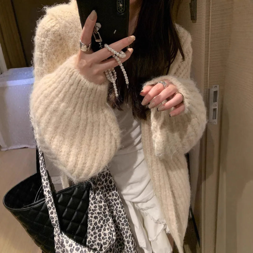 Woman wearing a thick dark grey hooded zip-up cardigan, loose fit.