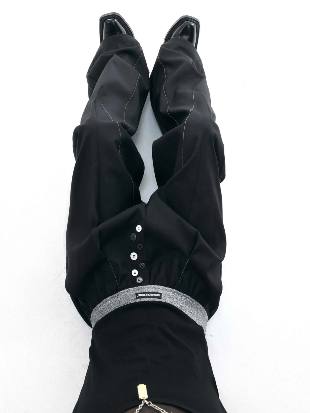 Straight-leg high-waisted trousers in grey fabric with button detail on the leg.