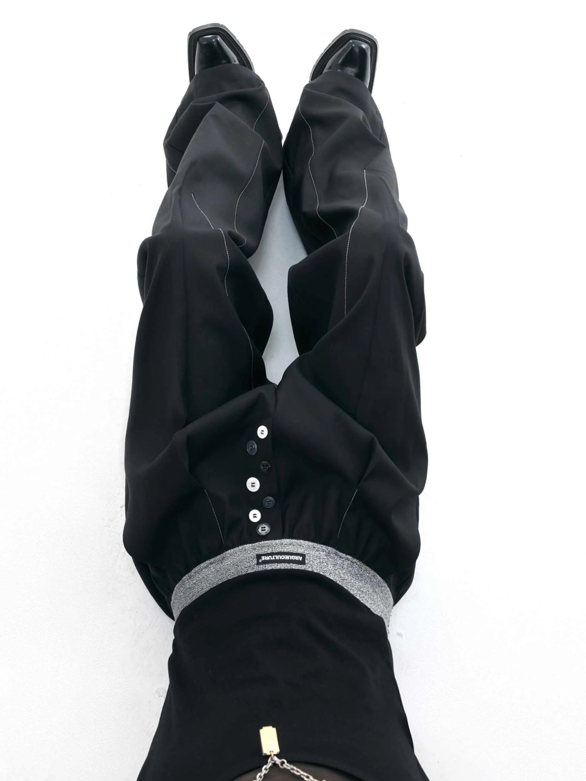 Straight-leg high-waisted trousers in grey fabric with button detail on the leg.