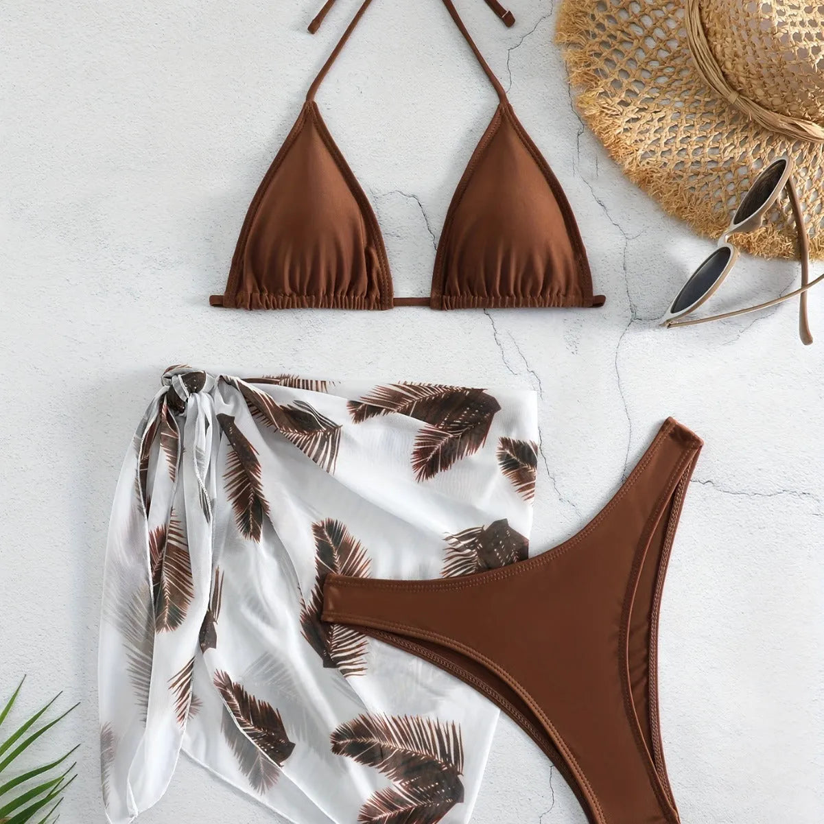 Orange three-piece bikini swimsuit set with a printed gauze skirt on a white background