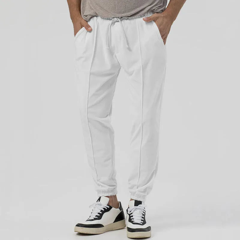 Men's grey straight-leg track sweatpants with a mid-waist, showcasing a relaxed fit and casual style.