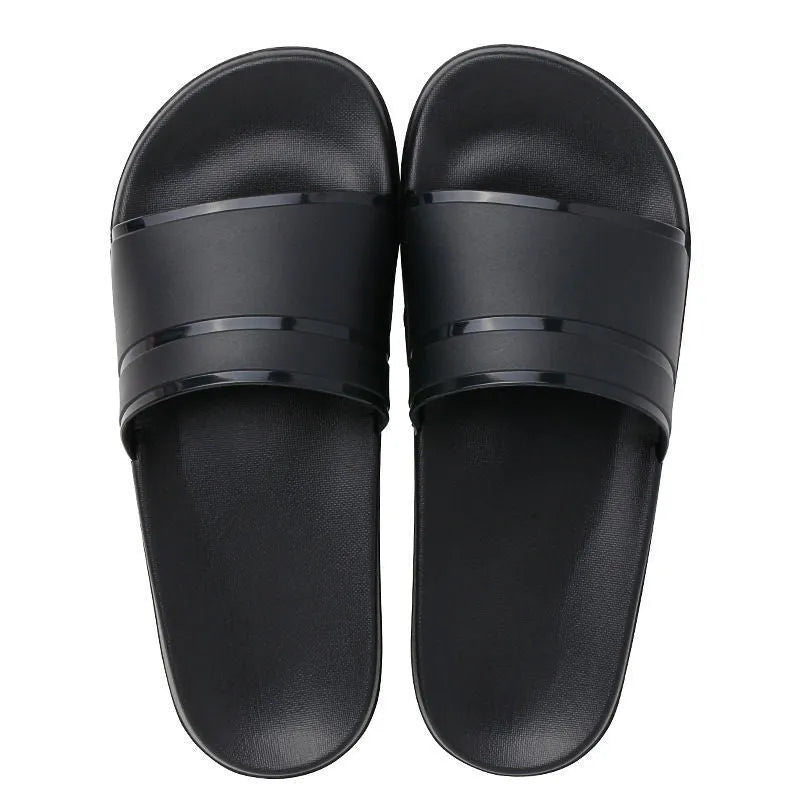 Unisex non-slip bathroom slippers in non-woven fabric with thick sole, available in black or white, sizes S to XXL