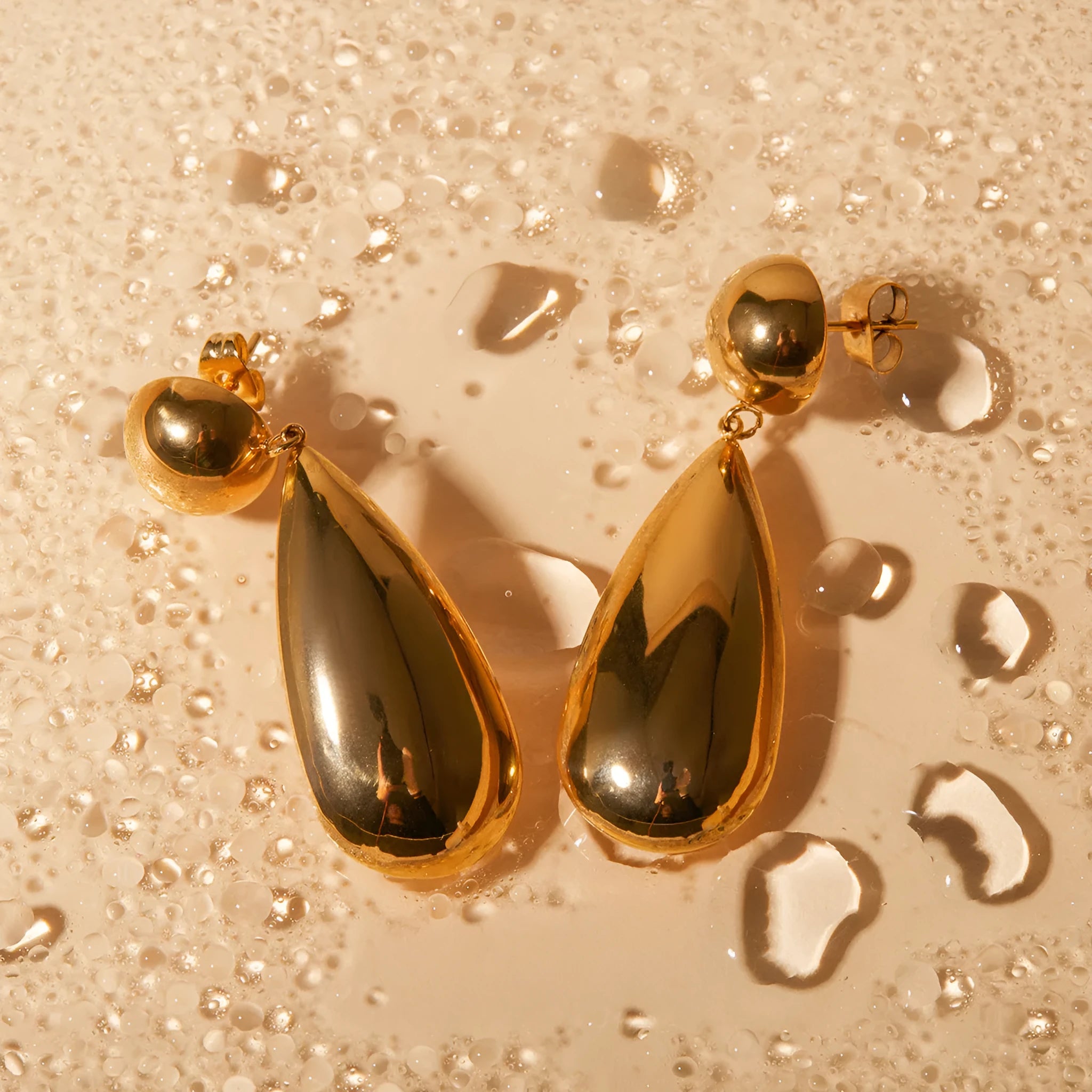 A pair of gold-coloured geometric water drop pendant earrings made from stainless steel.
