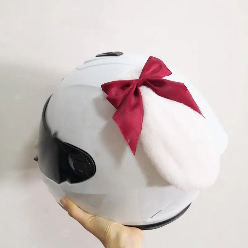 Carbon fibre rabbit ear decoration clipped onto a black motorcycle helmet, showing red colour variant.