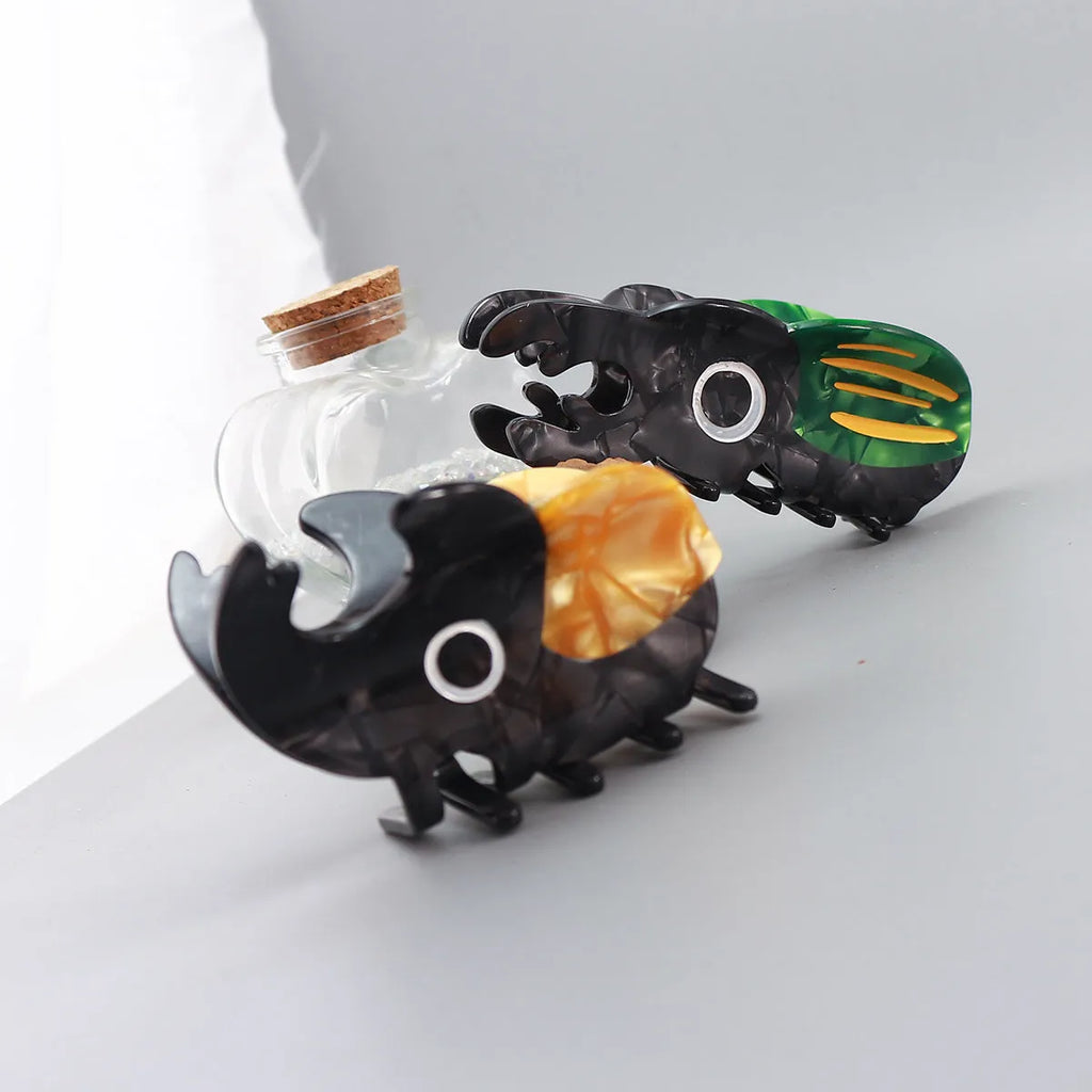 Handmade cellulose acetate beetle grip accessory with cartoon insect biology design in green or orange colour