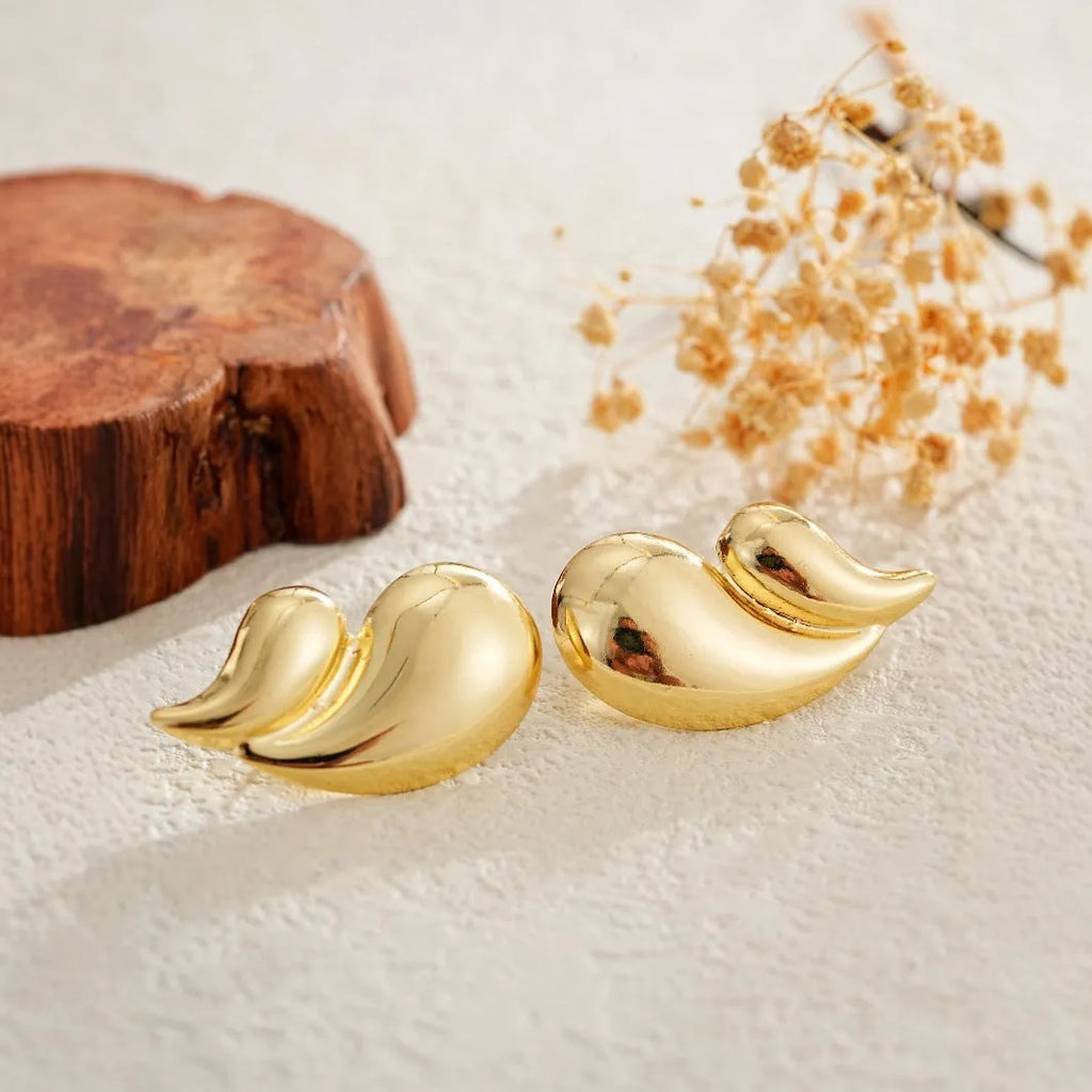 Gold water droplet minimalist dangle drop earrings on a white background