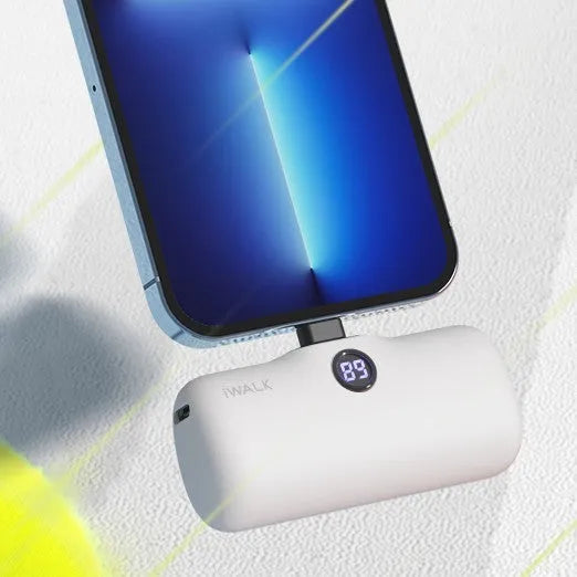 Small white cylindrical lipstick-shaped power bank showing digital battery percentage display on its side.