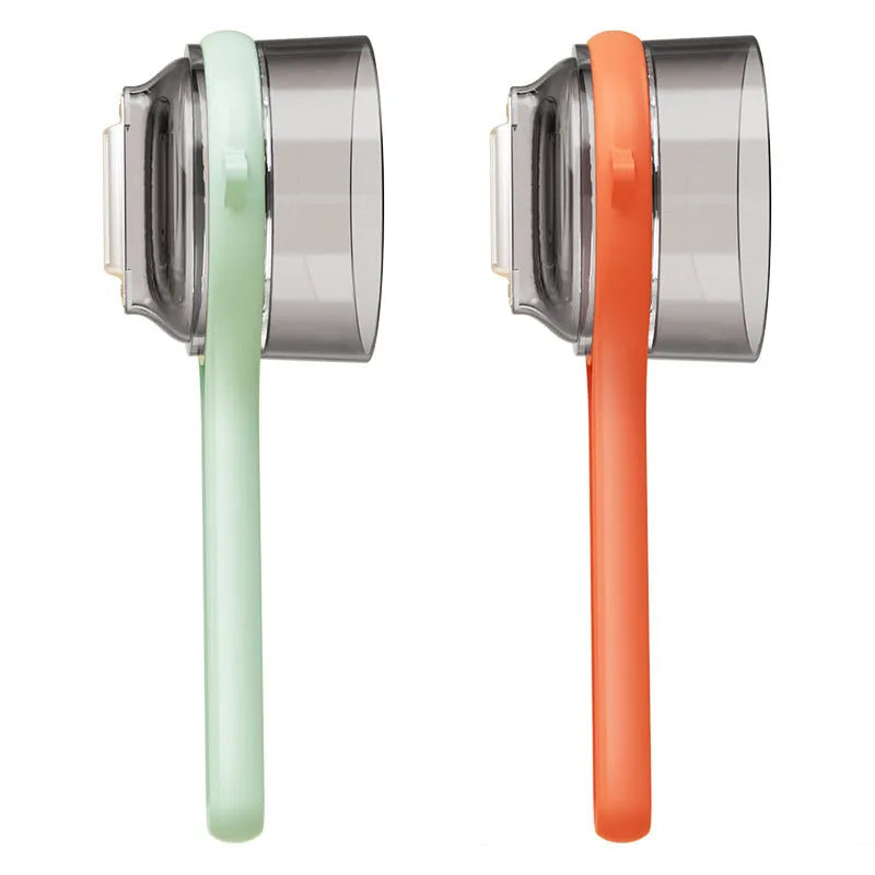 Light green kitchen peeler with a small orange storage bucket attached underneath the blade.