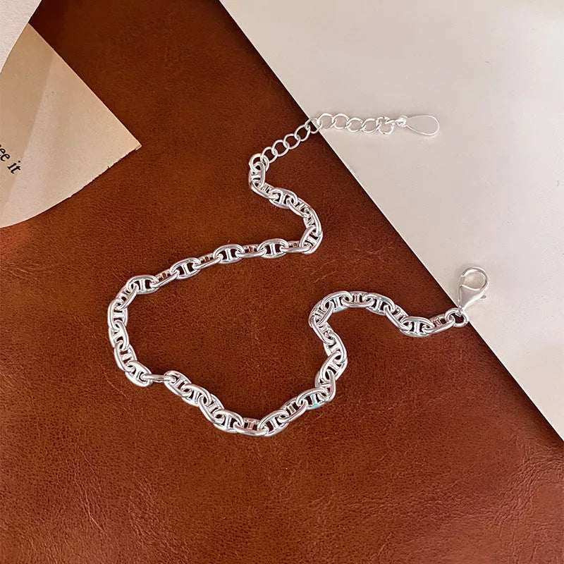 Minority stackable bracelet in polished 925 sterling silver pig nose chain style on white background