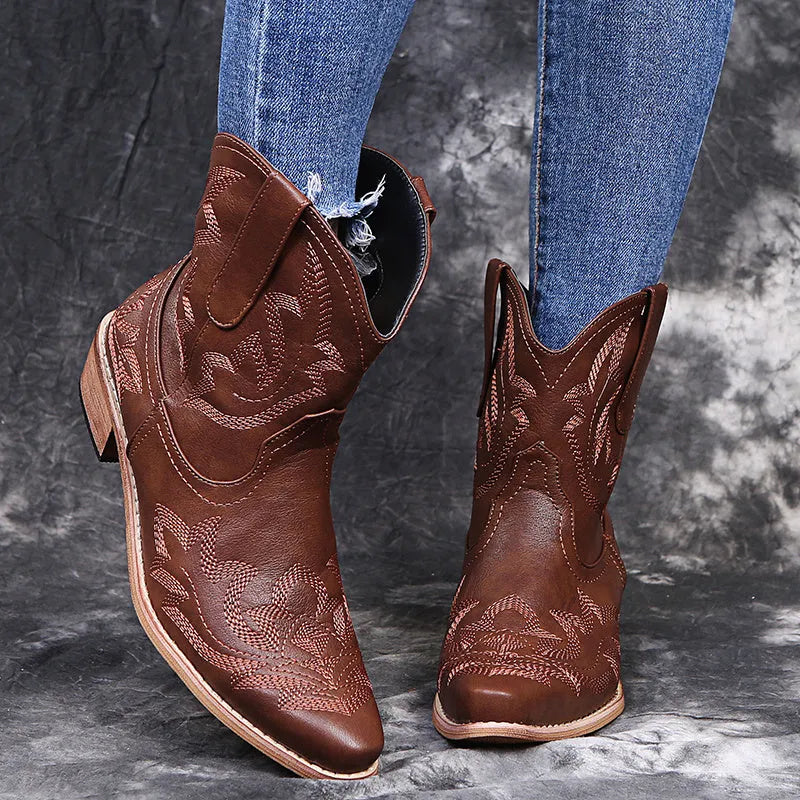 Women's blue embroidered cowboy boots with a wedge heel and pointed toe on a white background.