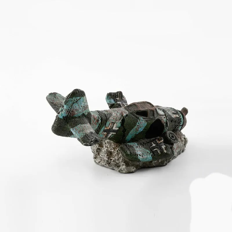 Resin simulated aircraft wreckage aquarium ornament 8cm by 4.5cm by 4.5cm on dark substrate