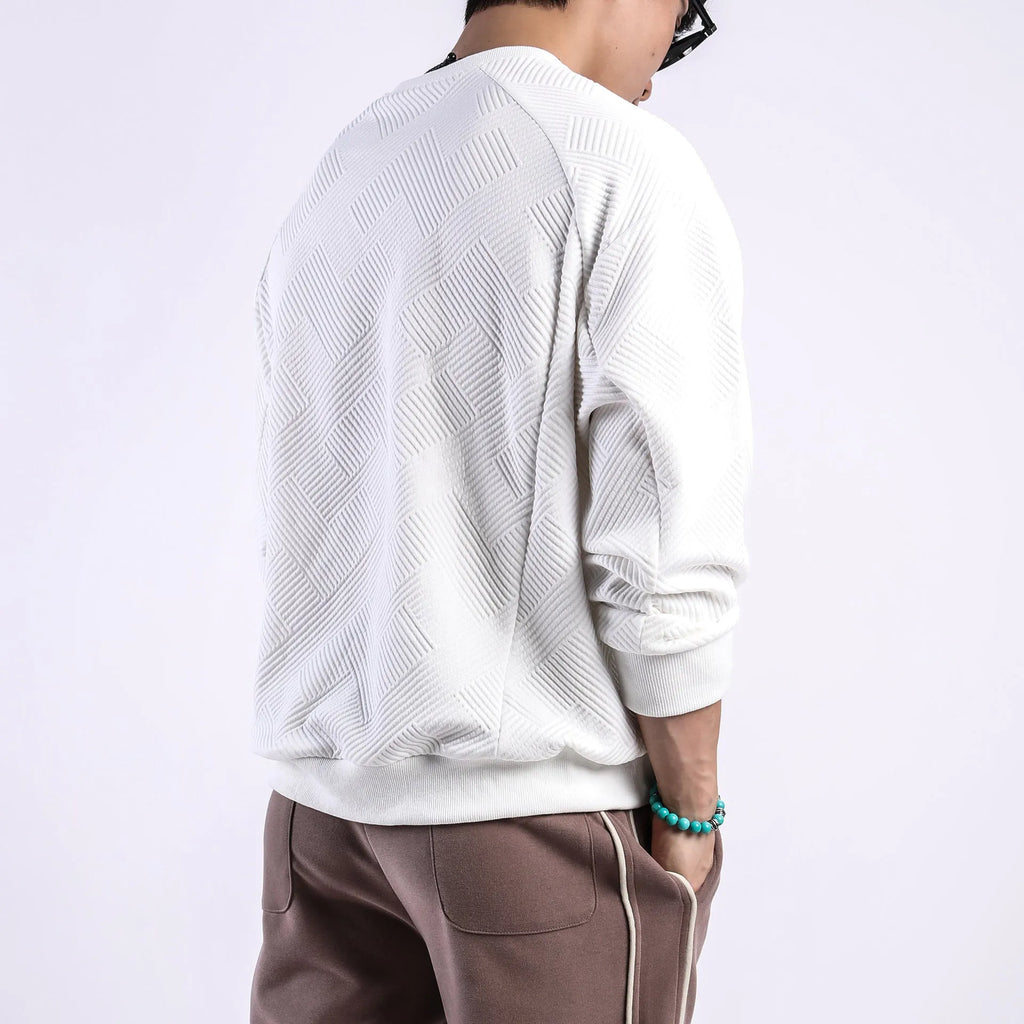 Man wearing a loose-fitting army green twill jacquard long-sleeved pullover sweater.