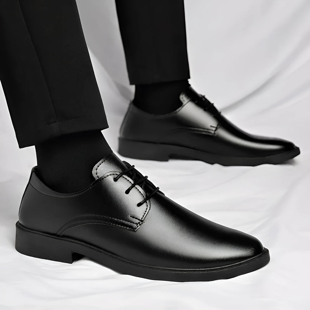 Men's black round toe pointed cap low top PU formal shoes with stitched detailing on white background