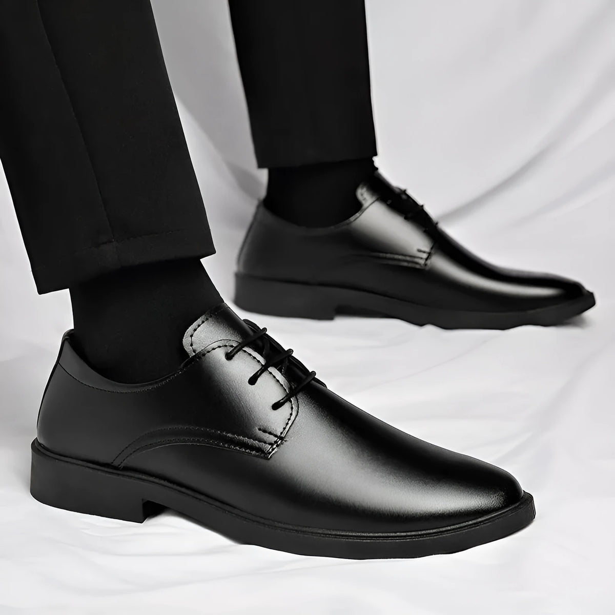 Men's black round toe pointed cap low top PU formal shoes with stitched detailing on white background
