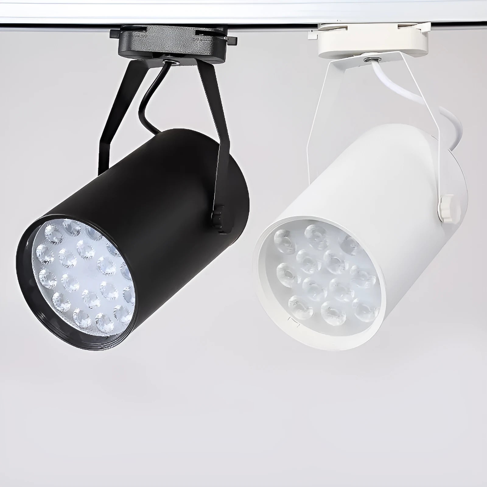 Black and white aluminium LED track spotlight on a lighting track, aimed at a display.