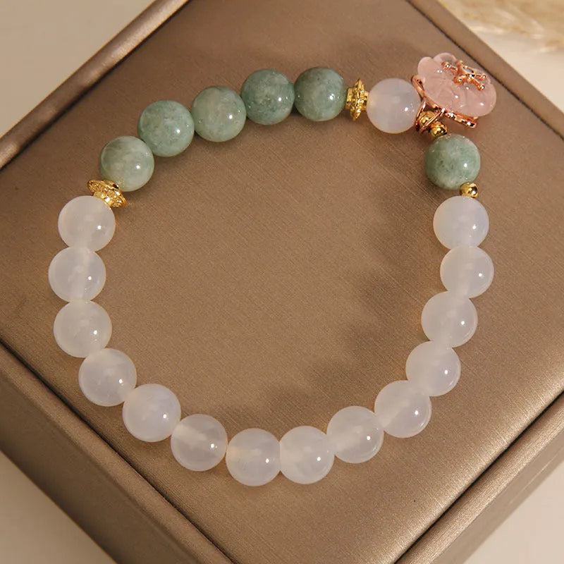White agate jade flower bracelet with pink accent stones on wrist