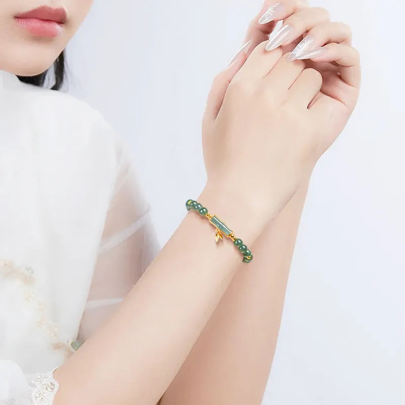 Women's silver bracelet with natural jade and blue beads in a simple high-rise design.