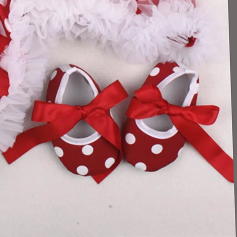 Four-piece newborn clothing set with cotton romper, headband, socks and shoes on display