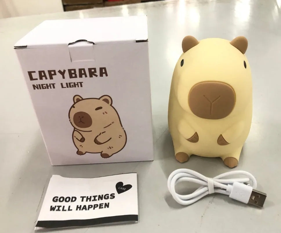 Cute brown Capybara silicone night lamp with soft glow on a bedside table.