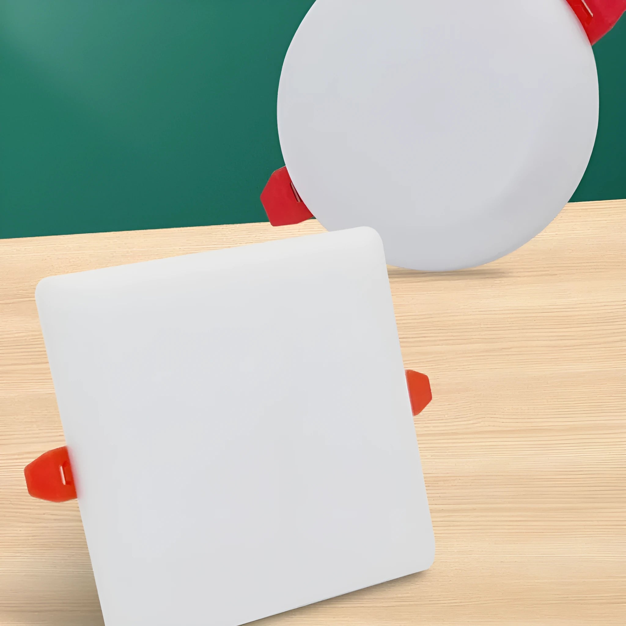 Ultra-thin circular and square aluminium LED panel ceiling lights showing white light.